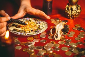 a witch holds a ritual for money burning a black candle